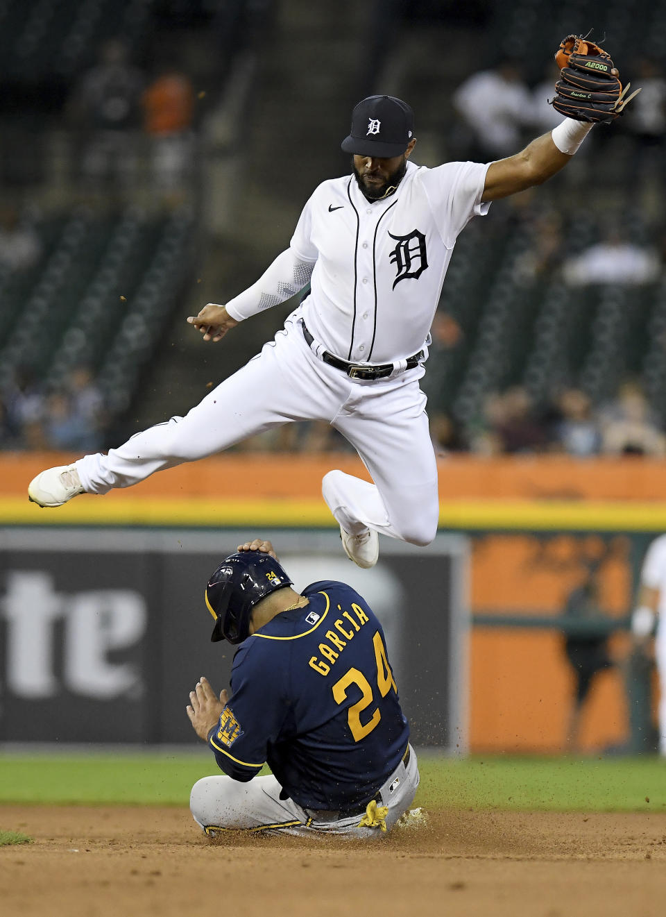 Milwaukee Brewers' Avisaíl García slides under Detroit Tigers shortstop Jeimer Candelario on a steal of second base during the fourth inning of a baseball game in Detroit, Tuesday, Sept. 14, 2021. (AP Photo/Lon Horwedel)