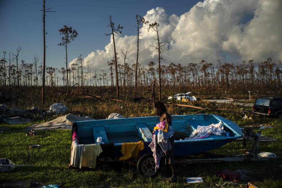 Valentino Ingraham washes clothing to remove salt and dirt amid the rubble of his mother's property destroyed by Hurricane Dorian in Rocky Creek East End, Grand Bahama, Bahamas, Sunday, Sept. 8, 2019. The motors of his family's boats were also destroyed. (AP Photo/Ramon Espinosa)