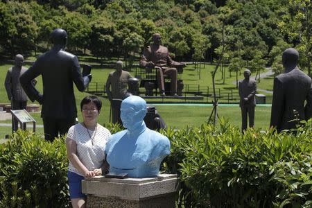 A woman poses for a photo next to a statue of the late president and Nationalist leader Chiang Kai-shek in Taoyuan, nothern Taiwan, July 5, 2015. REUTERS/Pichi Chuang