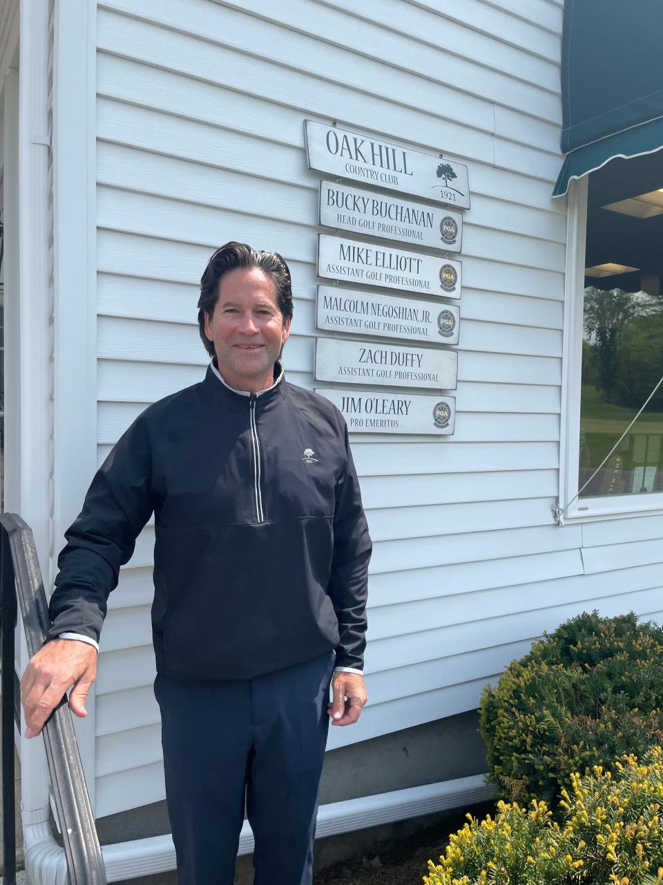 Former Leominster High standout Mike Elliott stands outside the pro shop, with his shingle over his shoulder, at Oak Hill Country Club in Fitchburg.