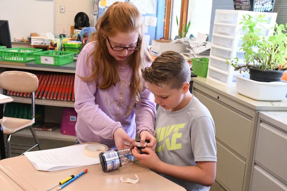West Branch fourth-graders work together to assemble a flashlight that is made out of a plastic bottle.
