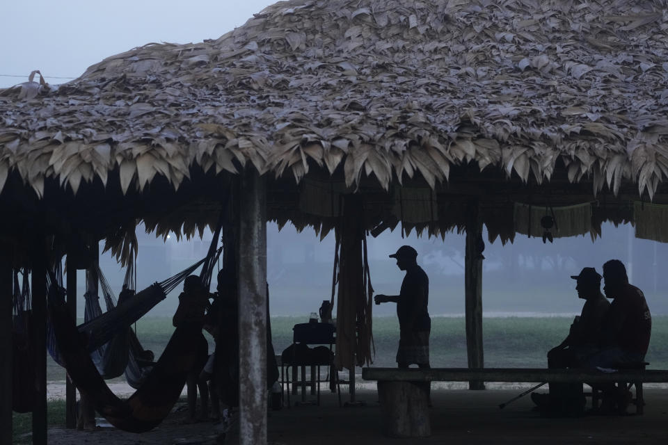 Al amanecer, indígenas se preparan para el segundo día del rito de madurez Wyra'whaw, en el centro ritual Ramada, en la aldea Tenetehar Wa Tembe, en la tierra indígena Alto Río Guamá, en el estado de Pará, Brasil, el 11 de junio de 2023. (AP Foto/Eraldo Peres)