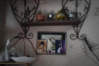 An old photo from the Quinceañera celebration of Mackyanis Yosney Romam Rodríguez, left, who is in prison along with her two brothers, accused of participating in the recent protests against the government, is seen on the wall in her home in the La Guinera neighborhood of Havana, Cuba , Wednesday, Jan. 19, 2022. Six months after surprising protests against the Cuban government, more than 50 protesters who have been charged with sedition are headed to trial and could face sentences of up to 30 years in prison. (AP Photo/Ramon Espinosa)