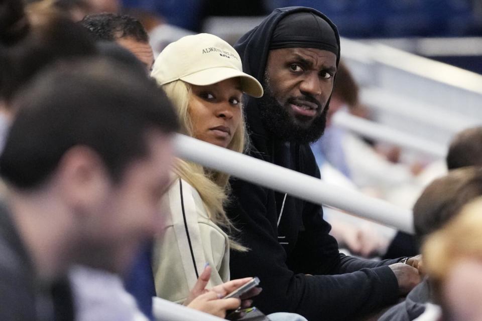 LeBron James, right, and his wife Savannah watch son Bronny from the stands during a scrimmage at the NBA draft combine.