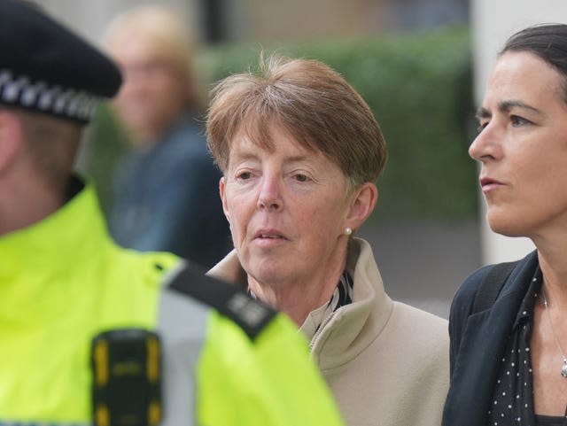 Paula Vennells walks behind a police officer