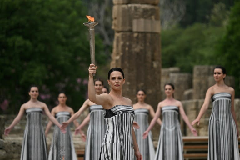 La actriz griega Mary Mina, interpretenado el papel de Suma Sacerdotisa, sostiene la llama olímpica durante la ceremonia de encendido de la antorcha de los Juegos de París, el 16 de abril de 2024 en Olimpia, al sur de Grecia (Aris Messinis)