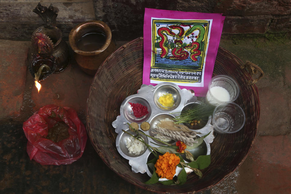 In this Aug. 5, 2019, photo, a traditional painting is seen in a basket containing materials used for rituals during Naag Panchami festival in Bhaktapur, Nepal. The art and tradition of Nepal’s Chitrakar families, who depicted gods and goddesses on temples, masks of Hindu deities and posters for various religious celebrations is dying because of mass machine printed posters and card-size pictures of gods that are cheaper and more popular. (AP Photo/Niranjan Shrestha)