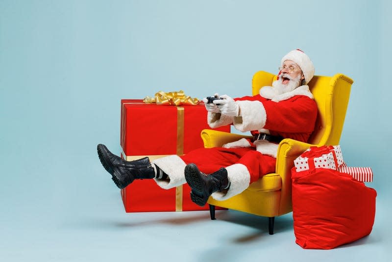 Gamer Santa holds a controller and kicks up his heels.