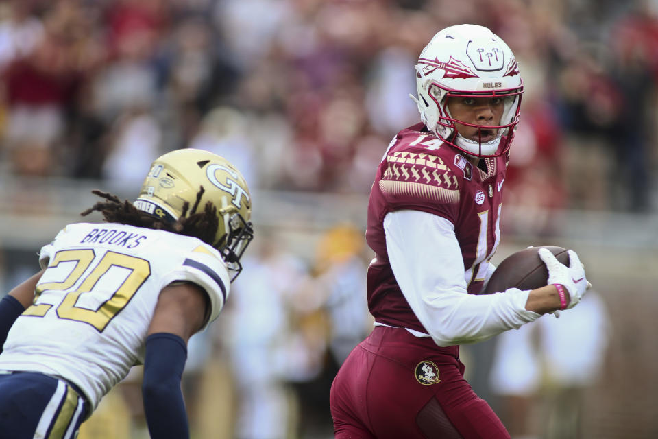 Florida State wide receiver Johnny Wilson, right, looks back at Georgia Tech defensive back LaMiles Brooks (20) as he runs for a touchdown after a short pass in the second quarter of an NCAA college football game Saturday, Oct. 29, 2022, in Tallahassee, Fla. (AP Photo/Phil Sears)