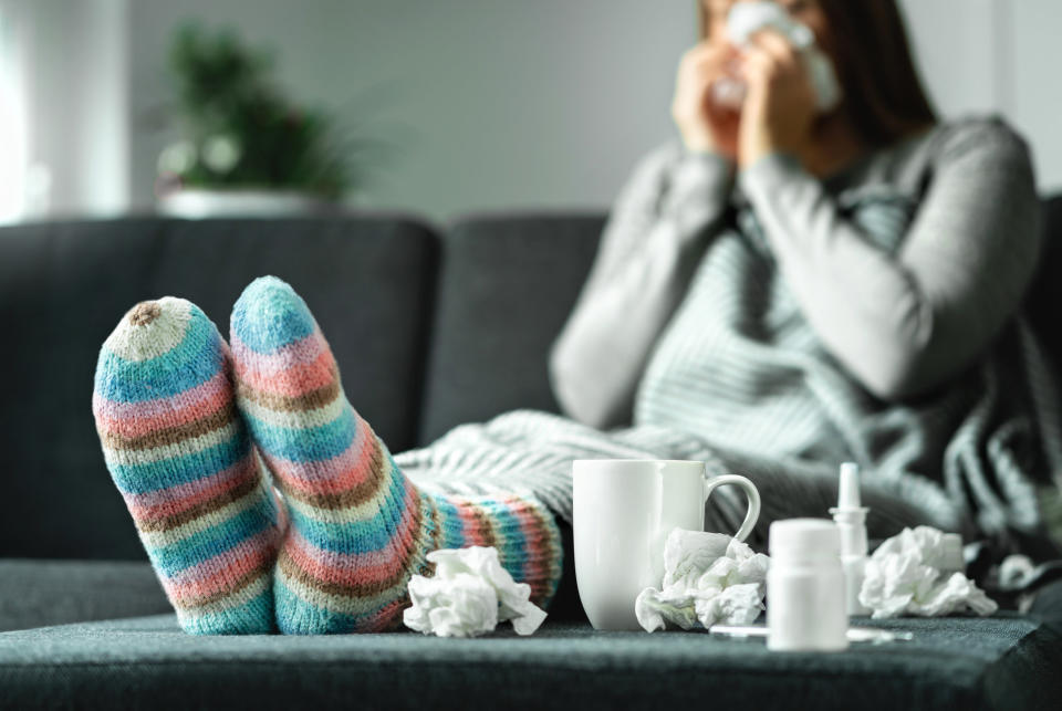 A sick woman blows her nose