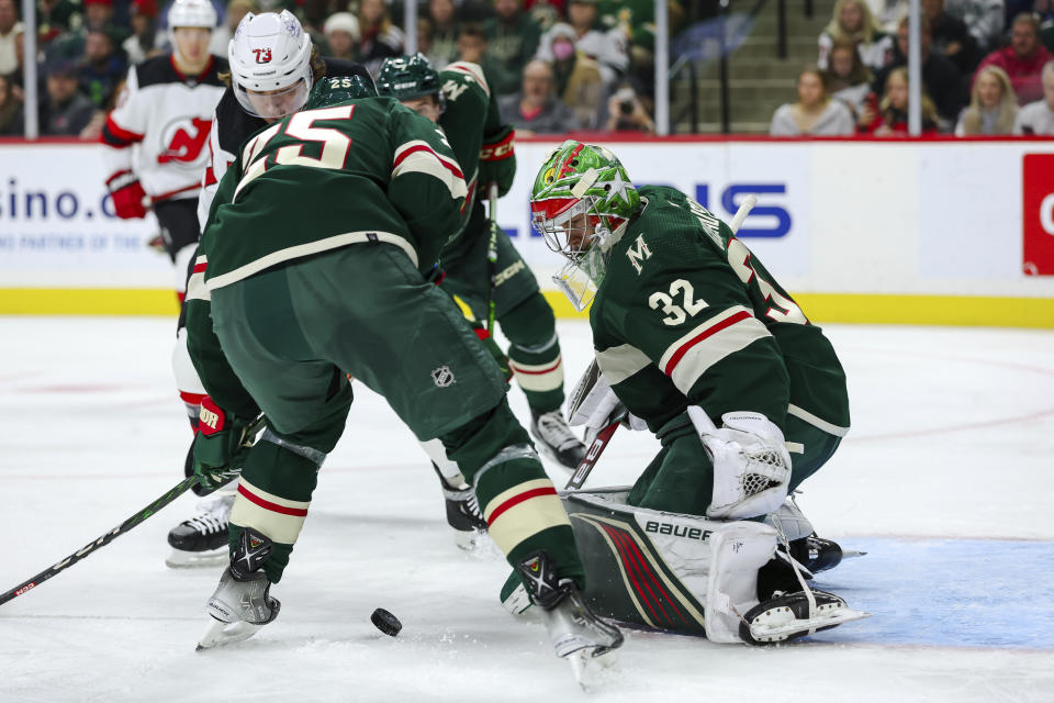 Minnesota Wild goaltender Filip Gustavsson, right, makes a save on a shot by New Jersey Devils center Tyler Toffoli (73) during the second period of an NHL hockey game, Thursday, Nov. 2, 2023, in St. Paul, Minn. (AP Photo/Matt Krohn)