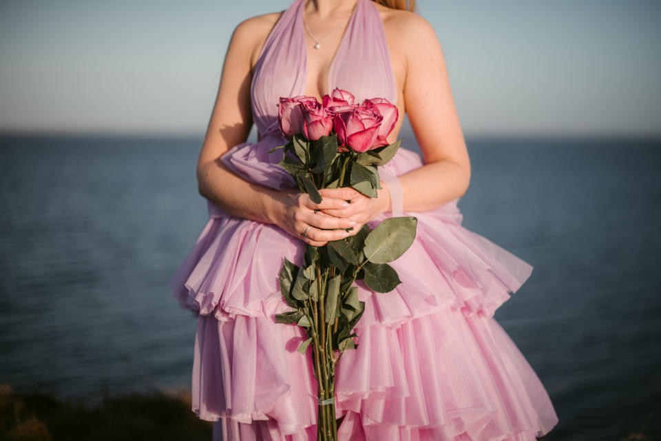 person wearing a blush wedding dress and holding flowers