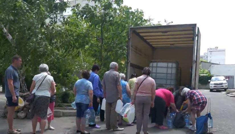 Residents of the southern Ukrainian port city of Mykolaiv line up for food and water rations amid Russia's invasion and sea blockade of their country, in early June, 2022. / Credit: CBS News