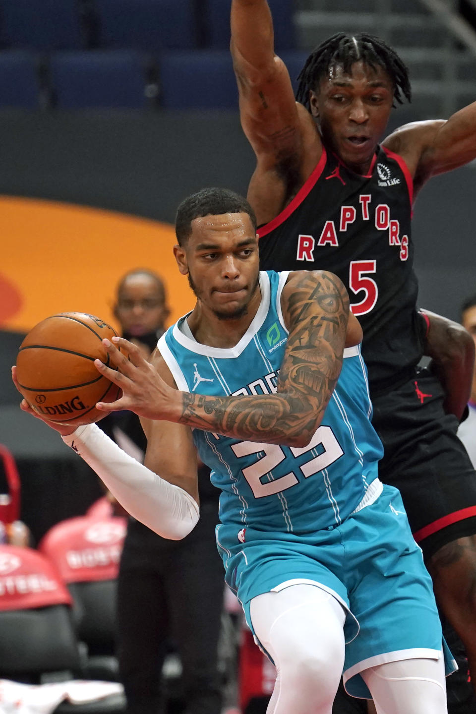 Charlotte Hornets forward P.J. Washington (25) makes a pass in front of Toronto Raptors forward Stanley Johnson (5) during the first half of an NBA basketball game Saturday, Jan. 16, 2021, in Tampa, Fla. (AP Photo/Chris O'Meara)