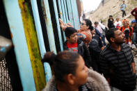 <p>Members of a caravan of migrants from Central America gather at the border fence between Mexico and the U.S. as part of a demonstration, prior to preparations for an asylum request in the U.S., in Tijuana, Mexico April 29, 2018. (Photo: Edgard Garrido/Reuters) </p>