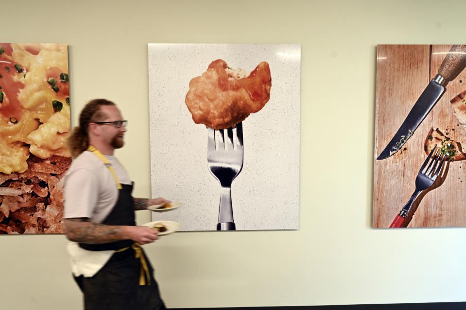 Chef Zach Tyndall carries plates of cultivated chicken at GOOD Meat's Alameda, Calif., headquarters on Thursday, Sept. 28, 2023. The company is one of over 150 startups aiming to use cell biology to reduce the environmental impact of the world’s ever-increasing demand for meat and change global protein production. (AP Photo/Noah Berger)