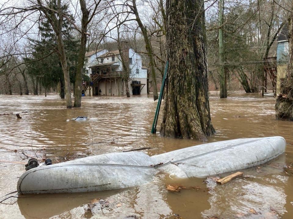 The Neshaminy Creek in Middletown nearly reached major flood stage after a storm Wednesday. A canoe sits ruined on Periwinkle Avenue as flood waters take over the street