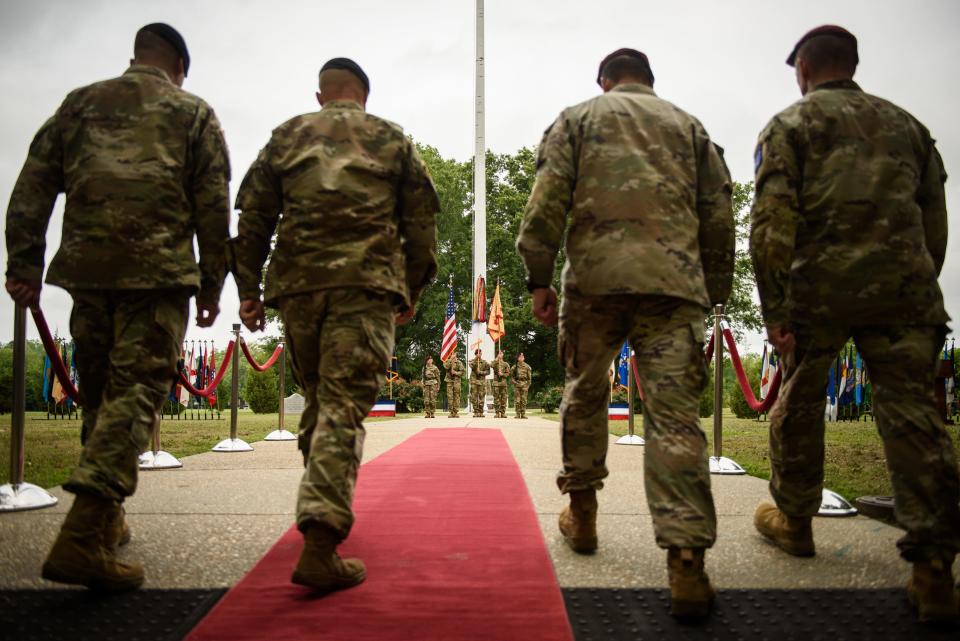 Command Sgt. Maj. Gregory Seymour, left to right, Col. John Wilcox, Lt. Gen. Christopher Donahue and Command Sgt. Maj. T.J. Holland walk out to case and uncase the garrison colors during the Fort Liberty redesignation ceremony on Friday, June 2, 2023.