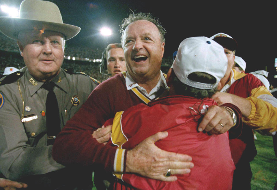 FILE - In this Jan. 1, 1994, file photo, Florida State University head football coach Bobby Bowden, center, receives a congratulatory hug after FSU defeated Nebraska 18-16 in the Orange Bowl in Miami. Bowden, the folksy Hall of Fame coach who built Florida State into an unprecedented college football dynasty, has died. He was 91. Bobby's son, Terry, confirmed to The Associated Press that his father died at home in Tallahassee, Fla., surrounded by family early Sunday, Aug. 8, 2021. (AP Photo/Doug Mills, File)