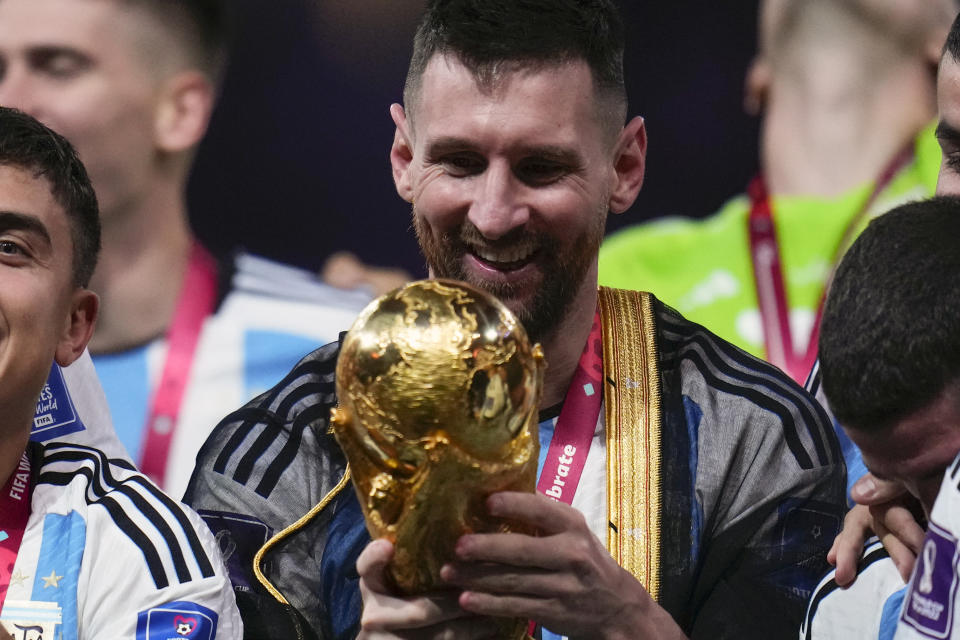 Argentina's Lionel Messi holds the trophy after winning the World Cup final soccer match between Argentina and France at the Lusail Stadium in Lusail, Qatar, Sunday, Dec.18, 2022. (AP Photo/Manu Fernandez)