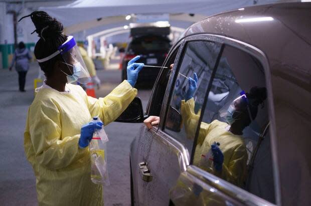 A nurse performs a test on a patient at a drive-in COVID-19 clinic in Montreal in October 2020. Ottawa's drive-thru test site recently expanded its hours, and now clinics in Nepean and Orléans are doing the same. (Paul Chiasson/Canadian Press - image credit)