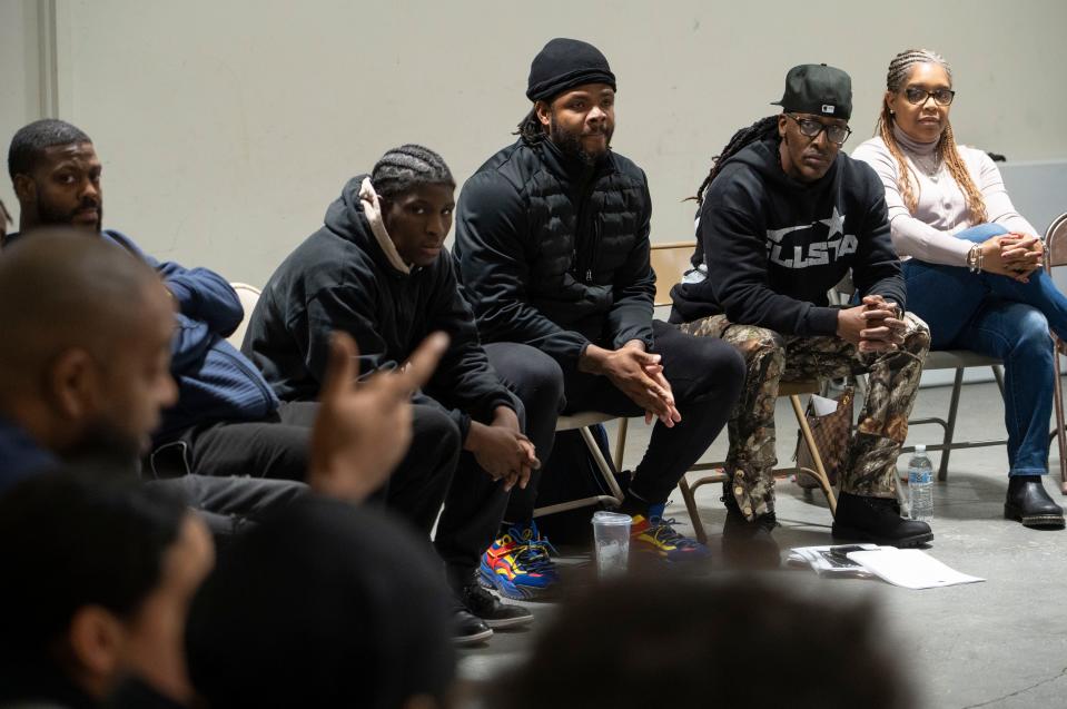 Kareem Hines, director of the New B.O.Y. mentoring program, second from right, listens during a weekly meeting of young men in the program Wednesday, Dec. 13, 2023, in Indianapolis. “They’ve created a safe space,” said Hines, where they can have candid conversations about issues in their lives as well as those facing the community.