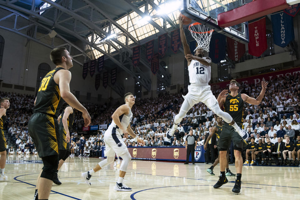 Penn State's Izaiah Brockington, center, goes up for the shot with Iowa's Luka Garza, right, defending during the first half of an NCAA college basketball game Saturday, Jan. 4, 2020, in Philadelphia. (AP Photo/Chris Szagola)