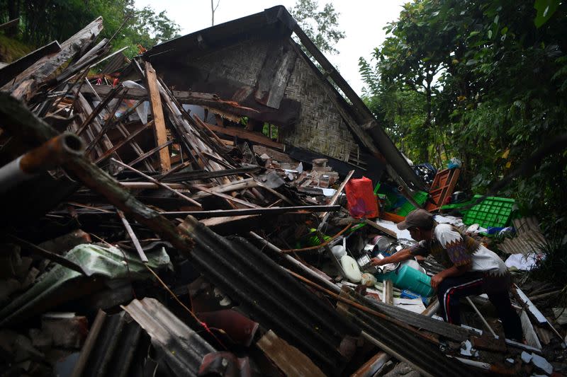 A man salvages his belongings at a house damaged by an earthquake in Lumajang