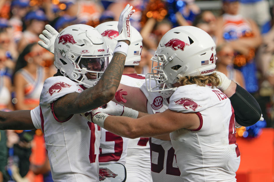 Arkansas wide receiver Tyrone Broden, left, celebrates with teammates after he made a touchdown catch to defeat Florida in overtime in an NCAA college football game, Saturday, Nov. 4, 2023, in Gainesville, Fla. (AP Photo/John Raoux)