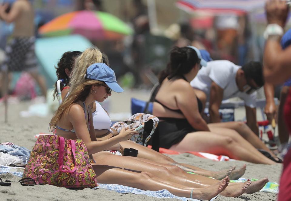 Cocoa Beach, Fla., is packed with Memorial Day beachgoers on Saturday, May 23, 202 The beaches are open for business again during the coronavirus epidemic. (Stephen M. Dowell/Orlando Sentinel via AP)