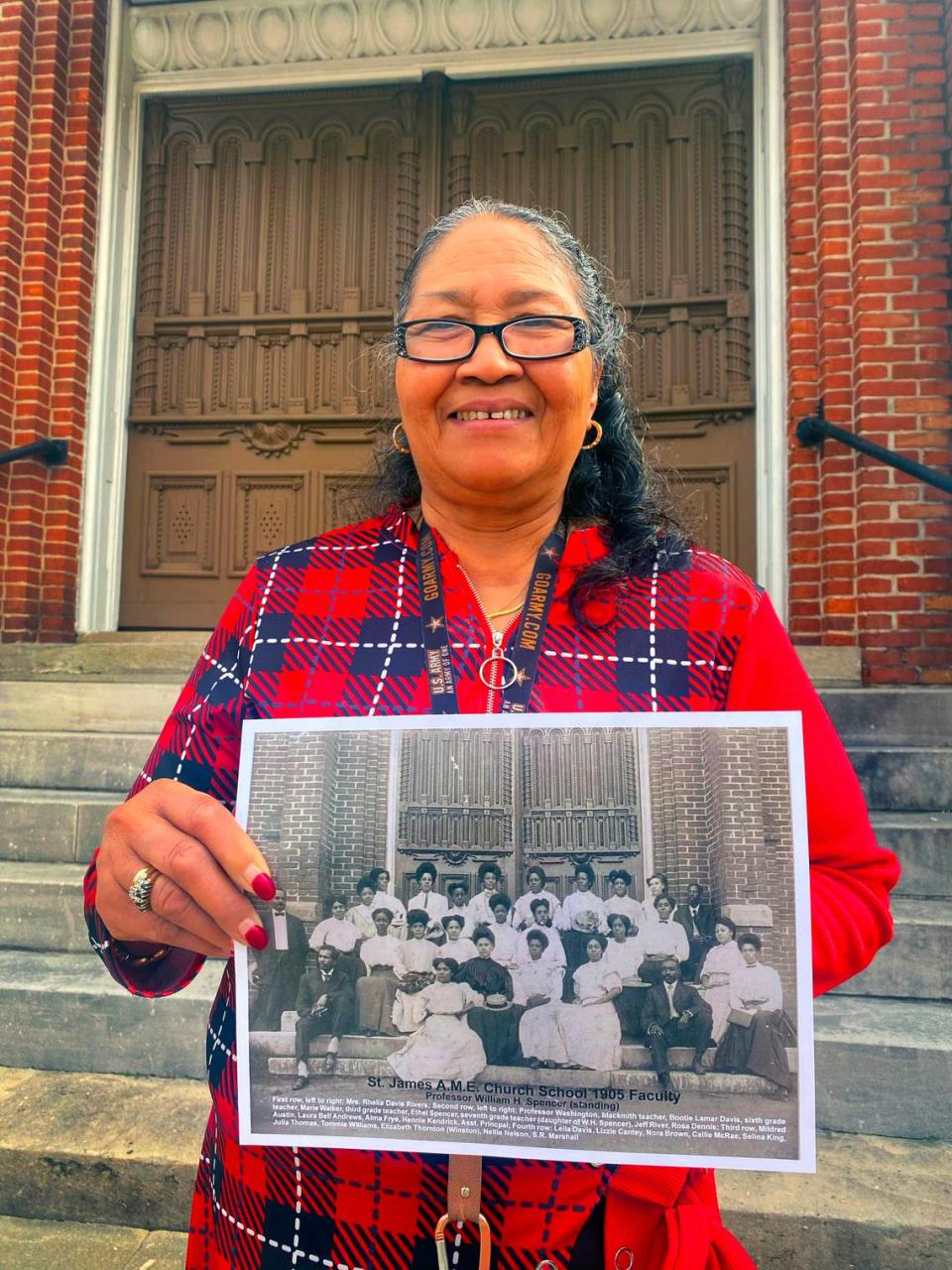 Carolyn Hensley, the church historian at Saint James A.M.E. Church in Columbus, Georgia, holds a photograph of the 1905 faculty of the church’s school. 02/16/2024
