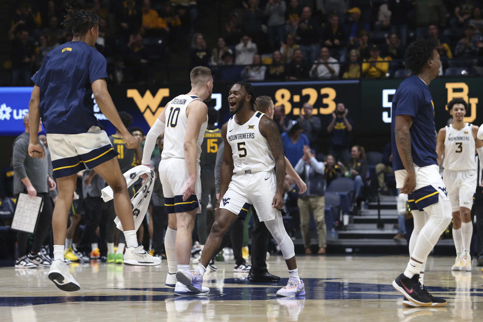 West Virginia players celebrate after a score against Baylor during the second half of an NCAA college basketball game in Morgantown, W.Va., Wednesday, Jan. 11, 2023. (AP Photo/Kathleen Batten)