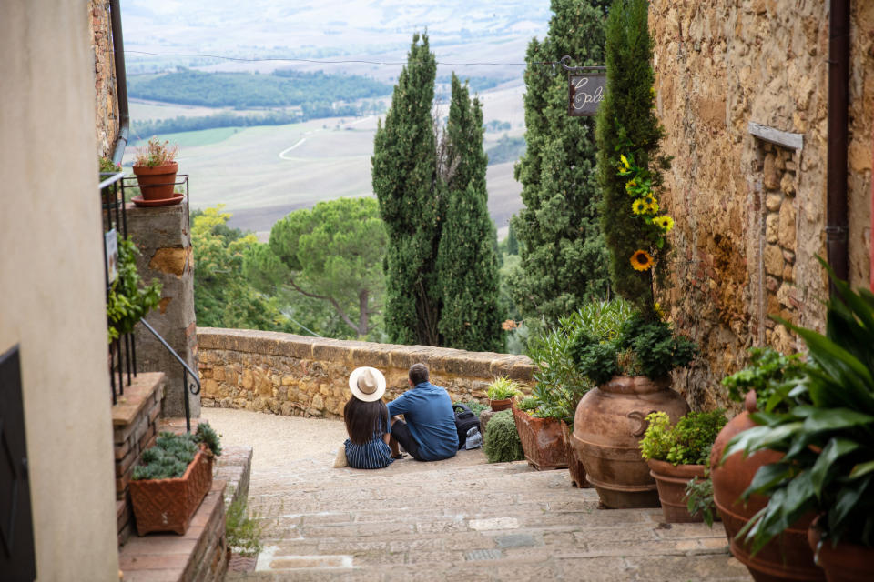 Rear wide angle shot of a couple sitting on the stairs enjoying a view.