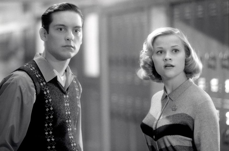 A woman stands with a man in a school hallway