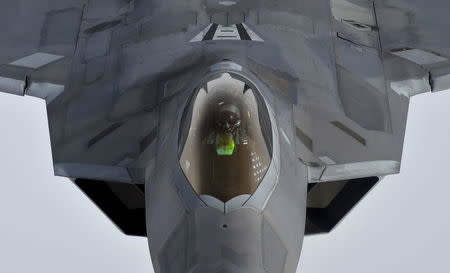 A pilot looks up from a U.S. F-22 Raptor fighter as it prepares to refuel in mid-air with a KC-135 refuelling plane over European airspace during a flight to Britain from Mihail Kogalniceanu air base in Romania April 25, 2016. REUTERS/Toby Melville