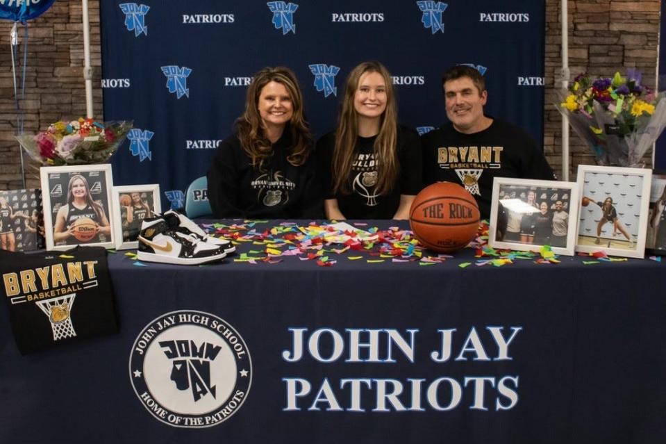 John Jay-East Fishkill basketball player Gabby Sweeney is flanked by her parents, Mary and Mike, during a ceremony as she signed a National Letter of Intent last month to play at Bryant University.