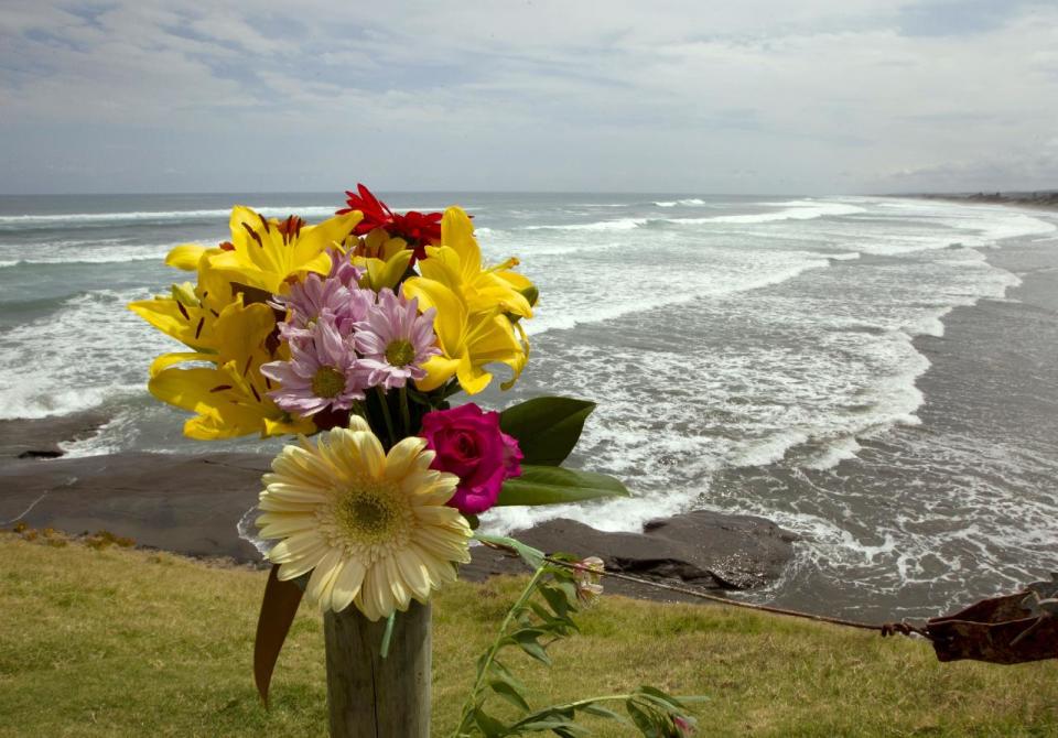 A flower tribute sits on a fence post as a memorial at Muriwai Beach near Auckland, New Zealand, Thursday, Feb. 28, 2013, a day after Adam Strange was killed by a shark. About 150 friends and family of Strange, 46, wrote messages to him in the sand and stepped into the water Thursday at a New Zealand beach to say goodbye after he was killed Wednesday by a large shark. (AP Photo/New Zealand Herald, Brett Phibbs) New Zealand Out, Australia Out