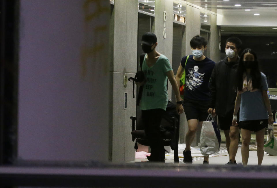 Protesters walk inside the campus of Polytechnic University in Hong Kong Friday, Nov. 22, 2019. Most of the protesters who took over the university last week have left, but an unknown number have remained inside for days, hoping somehow to avoid arrest. (AP Photo/Achmad Ibrahim)