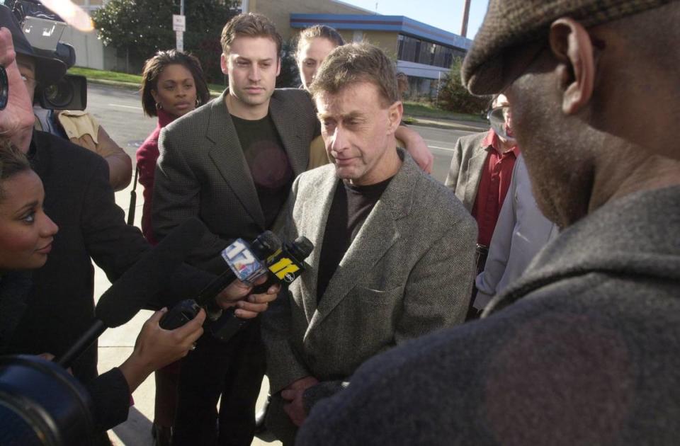 Michael Peterson (center) is surrounded by family members and reporters as he walks into the Durham County Courthouse to turn himself in for in connection with the death of his wife Kathleen Peterson.