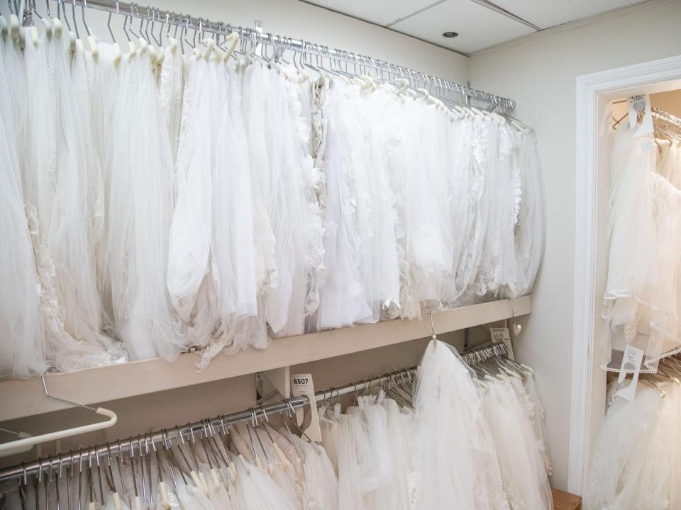 A room with wedding veils sitting on hangers in Kleinfeld.