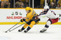 Nashville Predators right wing Eeli Tolvanen (28) battles for the puck with Columbus Blue Jackets defenseman Adam Boqvist (27) in the second period of an NHL hockey game Tuesday, Nov. 30, 2021, in Nashville, Tenn. (AP Photo/Mark Humphrey)