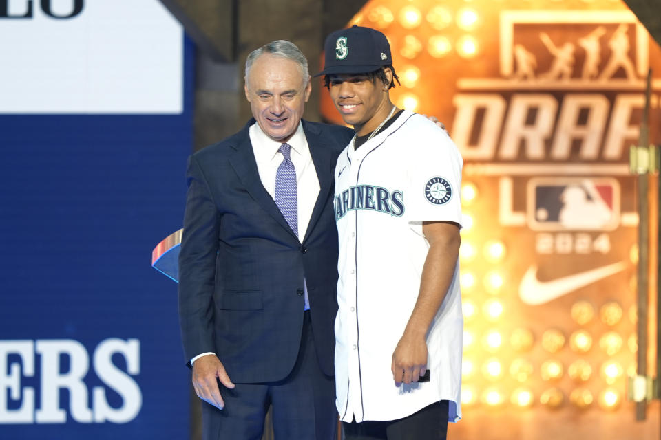 Major League Baseball Commissioner Rob Manfred, left, and Jurrangelo Cijntje, pose after Cijntje was selected 15th overall by the Seattle Mariners in the first round of the MLB baseball draft in Fort Worth, Texas, Sunday, July 14, 2024. (AP Photo/LM Otero)