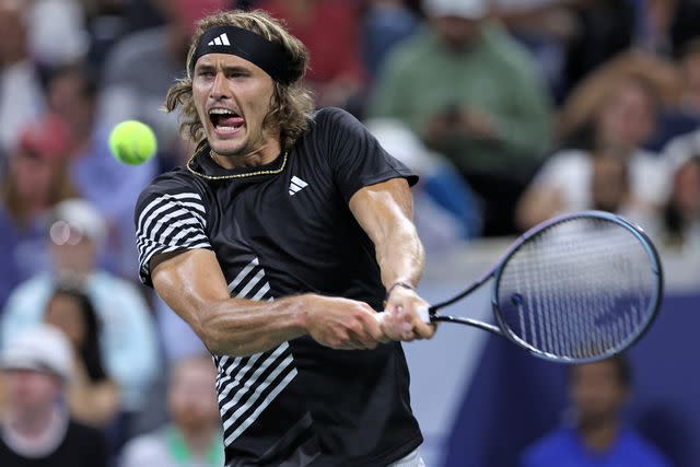 <p>Clive Brunskill/Getty</p> Alexander Zverev of Germany returns a shot against Grigor Dimitrov of Bulgaria during their Men's Singles Third Round match on Day Six of the 2023 US Open.