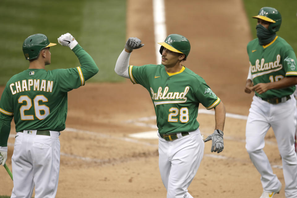 Oakland Athletics' Matt Olson (28) celebrates with Matt Chapman, left, after hitting a two run home run off Texas Rangers' Kyle Gibson in the first inning of a baseball game Wednesday, Aug. 5, 2020, in Oakland, Calif. (AP Photo/Ben Margot)