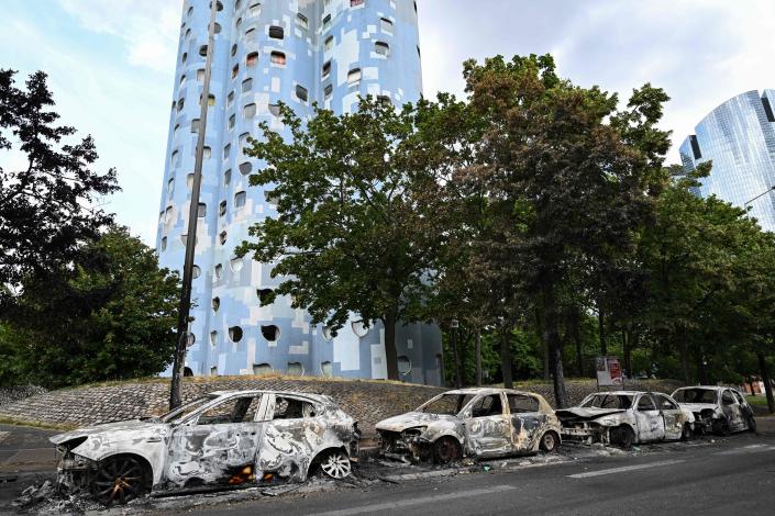 Burnt cars line the street at the foot of the Pablo Picasso estate in Nanterre, west of Paris on 30 June 2023 (AFP via Getty Images)