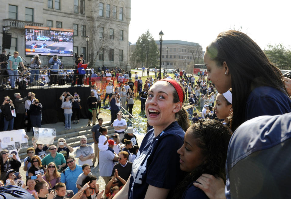 Connecticut's Breanna Stewart, center, looks back at Bria Hartley, top right, and Kaleena Mosqueda-Lewis, bottom, during a parade celebrating their team's NCAA women's college basketball championship, in Hartford, Conn., on Sunday, April 13, 2014. (AP Photo/Fred Beckham)