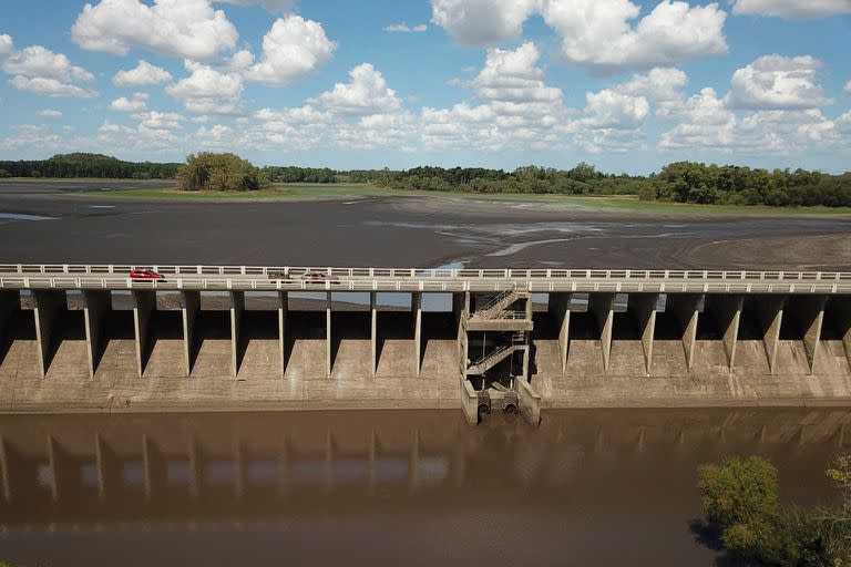 Picture of the dried Canelon Grande reservoir (top), the dam-bridge and stream (foreground) just north of Canelones, in southern Uruguay, taken on March 14, 2023, as the country goes through a severe drought. - The reservoir's main purpose is to supply drinking water to the Metropolitan area of Montevideo, while it is also used in irrigation systems in the area. (Photo by Pablo PORCIUNCULA / AFP)