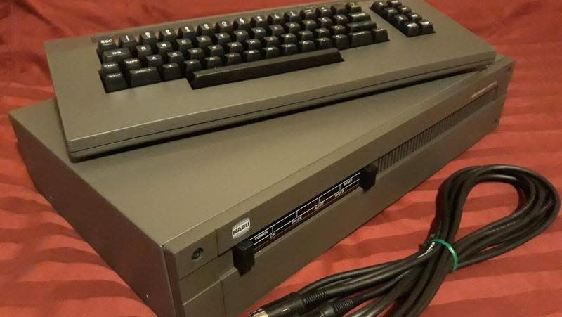 A NABU box with a keyboard and a adapter plug. 