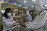 An employees of the Medicament Management Office of the Daesong District in Pyongyang provides medicine to a resident as the state increases measures to stop the spread of illness in Pyongyang, North Korea, Monday, May 16, 2022. (AP Photo/Jon Chol Jin)