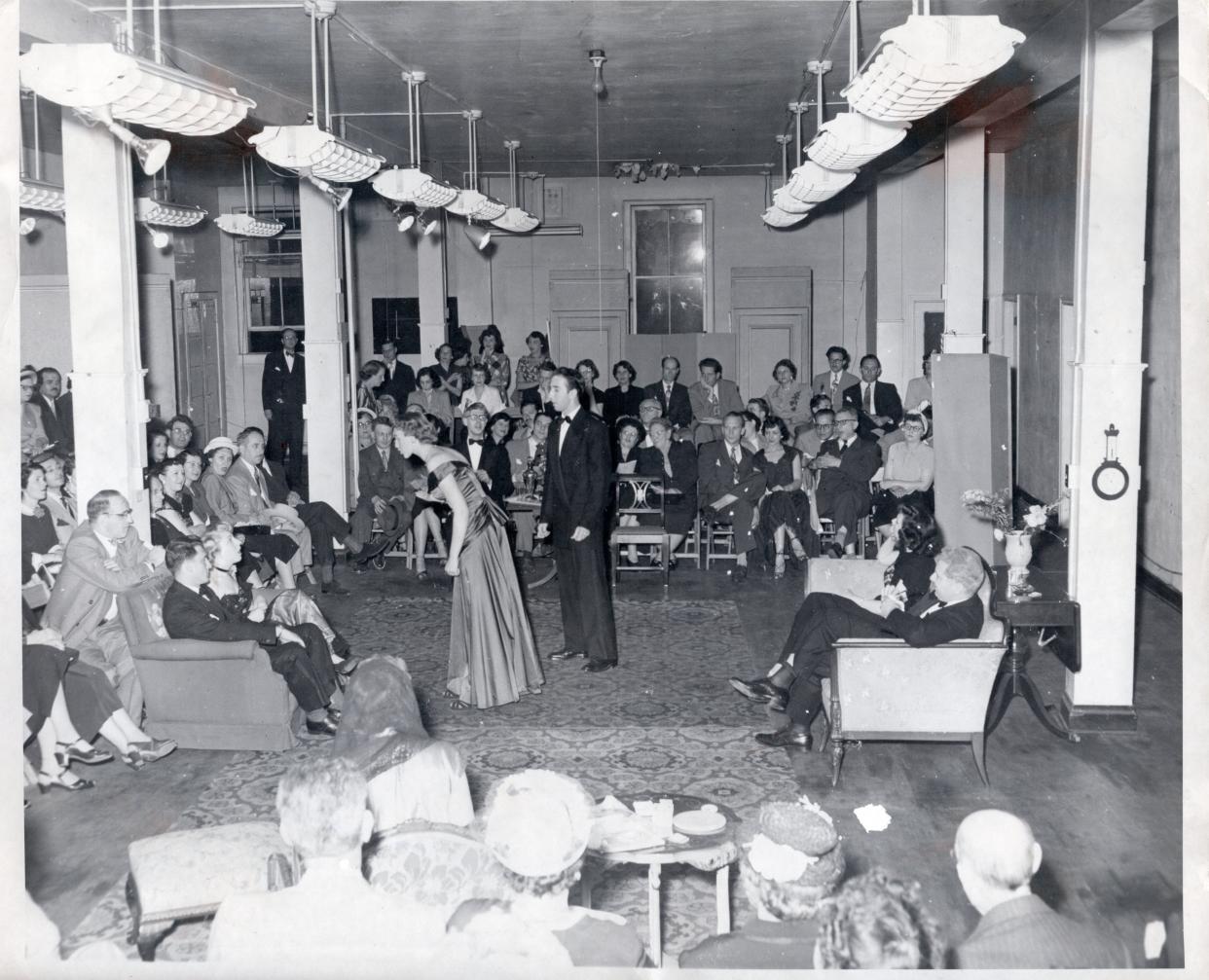 Theatergoers in 1950 watch actors in Gallery Players’ arena-style debut production of Noel Coward’s “Hay Fever” in the troupe’s first home in the top-floor loft or “gallery” of a shoe factory at 80½ E. Long St.